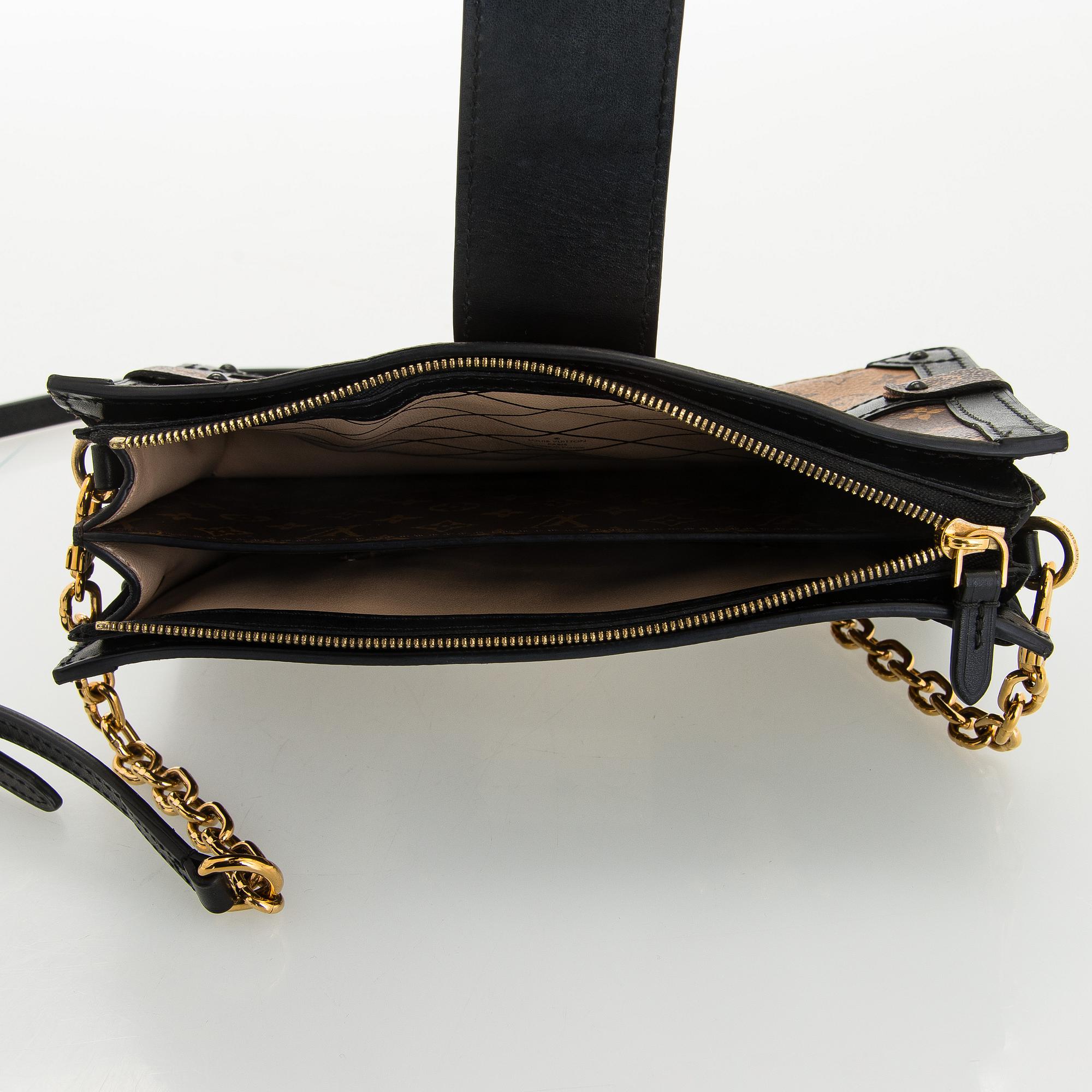 Louis Vuitton, a "Reverse Monogram Trunk Clutch" bag.
