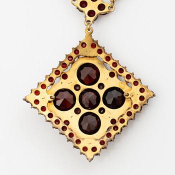 Pendant and a pair of earrings, gilt metal with garnets.