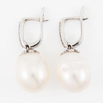 A pair of 14K gold earrings with cultured freshwater pearls and round brilliant-cut diamonds.