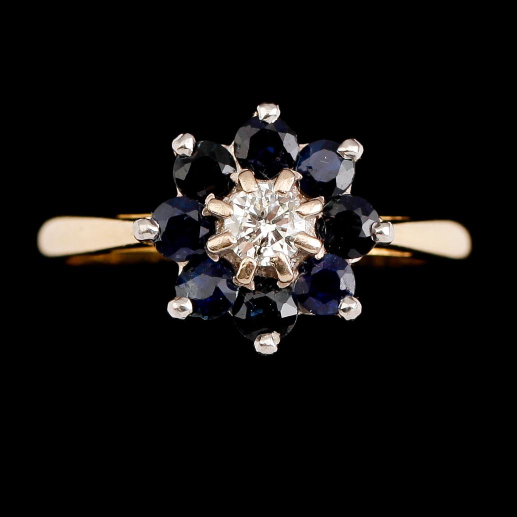 RING, 18 k guld med briljantslipad diamant samt 8 blå safirer. Total vikt ca 3 gram.