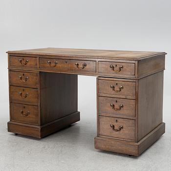 A mahogany and mahogany veneer desk with desk chair, 20th Century.