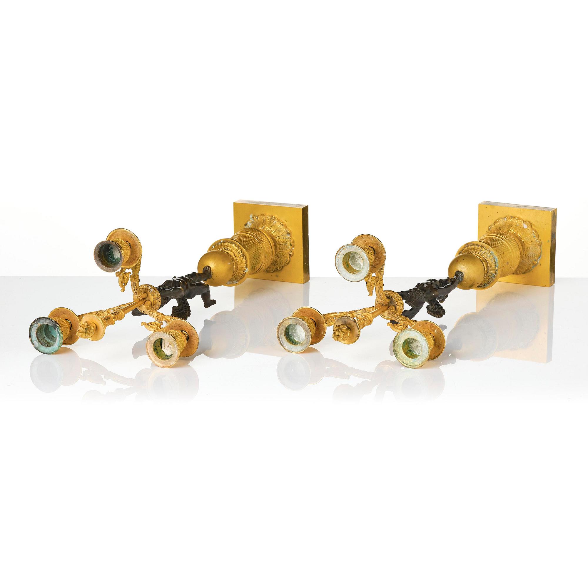 A pair of Empire three light ormolu and patinated bronze candelabra.