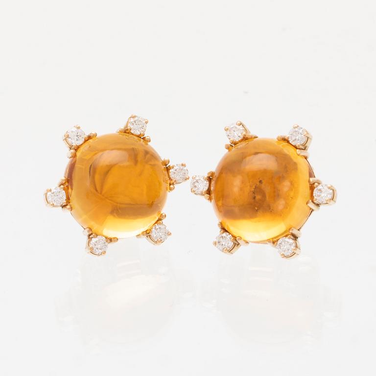 A pair of 18K gold earrings set with cabochon cut citrines and round brilliant cut diamonds.