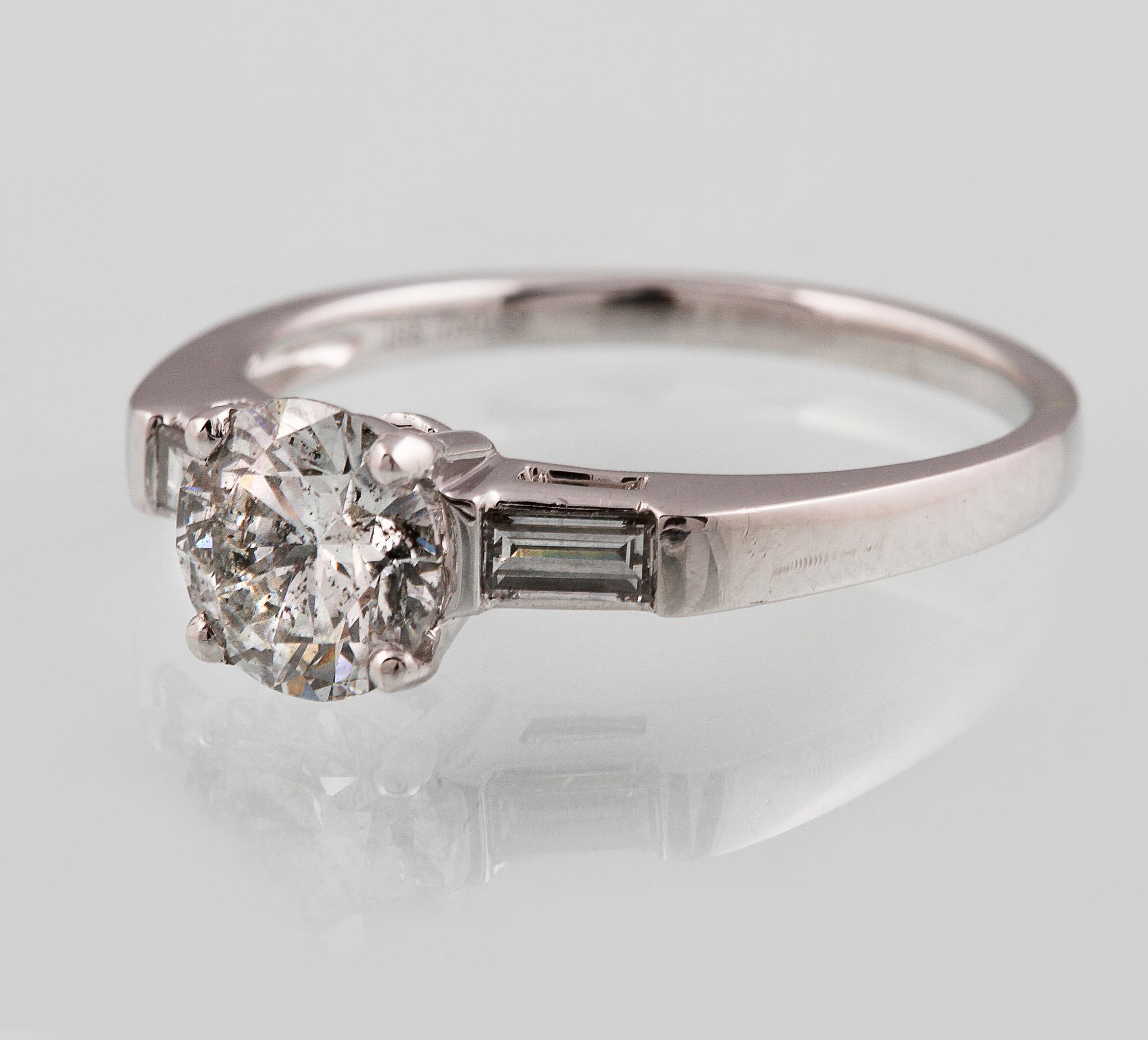 RING, 18K vitguld med briljantslipad diamant ca 1.05 ct samt 2 baguettslipade diamanter ca 0.17 ct. Vikt 3,2 gram.