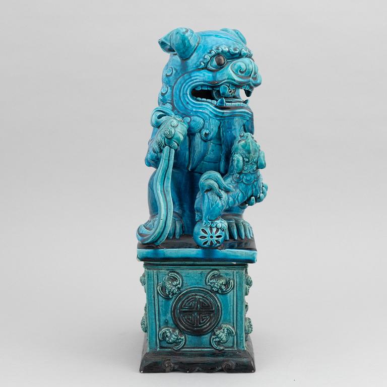 A Chinese seated buddhist lion on a plinth, 20th century.