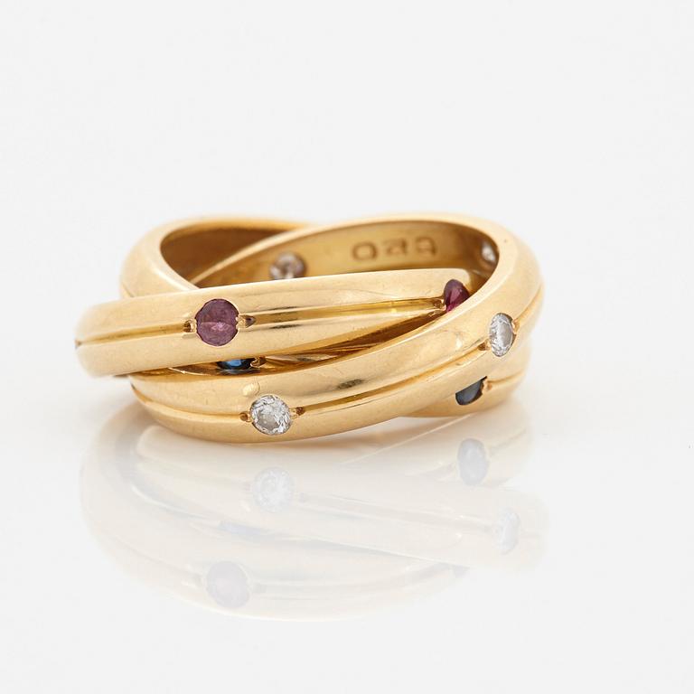 A Cartier "Trinity" ring in 18K gold set with round brilliant-cut diamonds, rubies and sapphires.