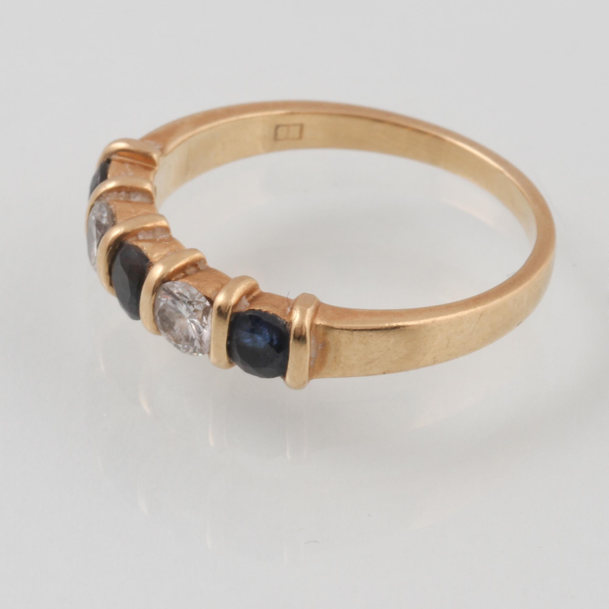 RING, 18K guld med 2 briljantslipade diamanter samt 3 fasettslipade blå safirer, kattfotstämplad. Vikt 2,9 gram.