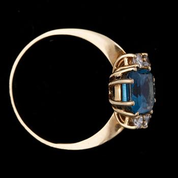 RING, 18k guld med blå topas och briljantslipade diamanter totalt ca 0,30 ct. Vikt ca 3,8 gram.