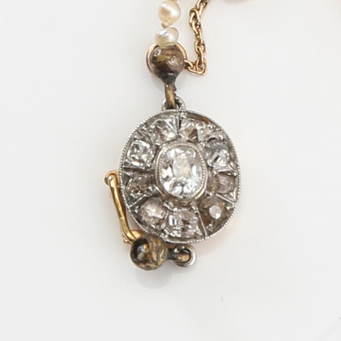 Necklace of cultured pearls with a clasp of gold set with diamonds.
