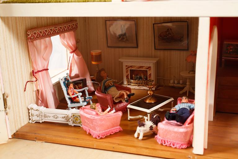 A 1980s doll house with various dolls and furniture.