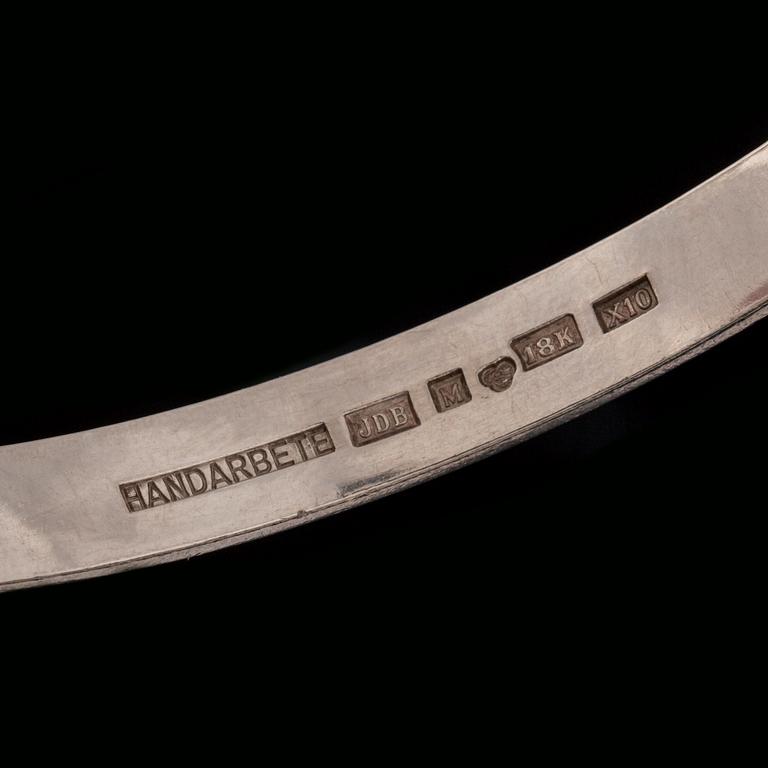ARMRING, 18 k vitguld med briljantslipad diamant ca 0.05 ct samt 2 fasettslipade safirer. Vikt ca 33 g.