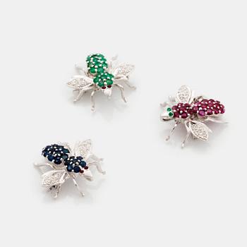 Tre broscher 18K vitguld med runda briljantslipade diamanter samt rubiner, safirer och smaragder.