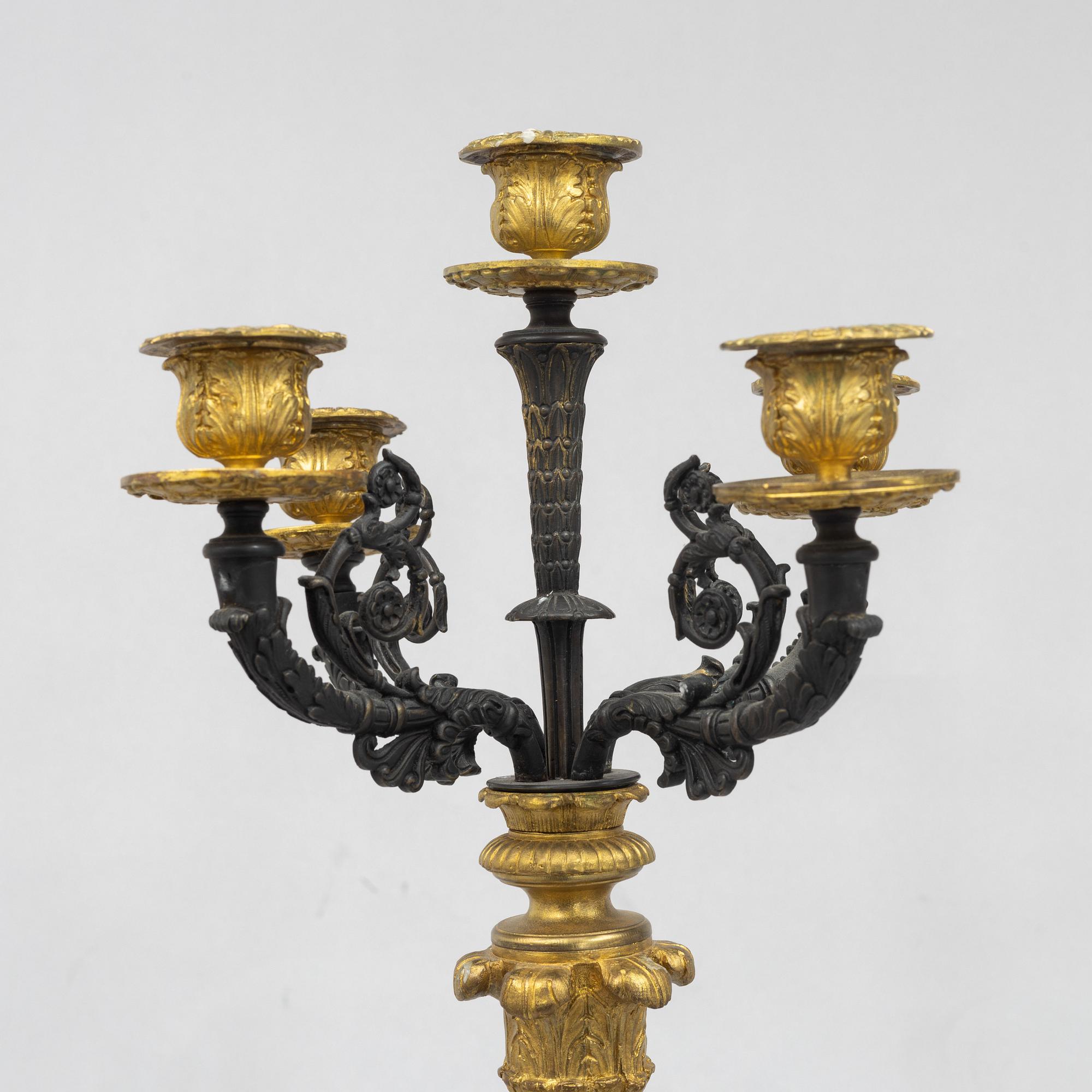A pair of French Empire-style patinated and gilt bronze five-light candelabra, later part 19th century.