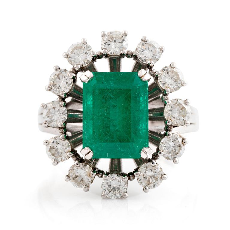 An emerald and round brilliant cut diamond ring.