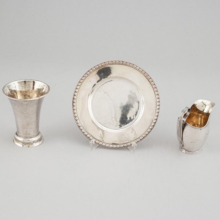 Beaker, silver 1835, cream-jug, silver 1826 and bread-plate, silver 1952.