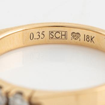 An 18K gold ring set with round briliiant-cut diamonds.
