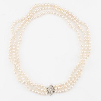 Necklace, pearls, three strands, clasp in 14K white gold with small diamonds.