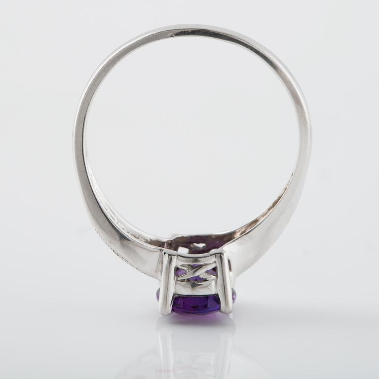 RING, 18K vitguld med 6 briljantslipade diamanter samt ovalsslipad ametist. Vikt 2,8 gram.
