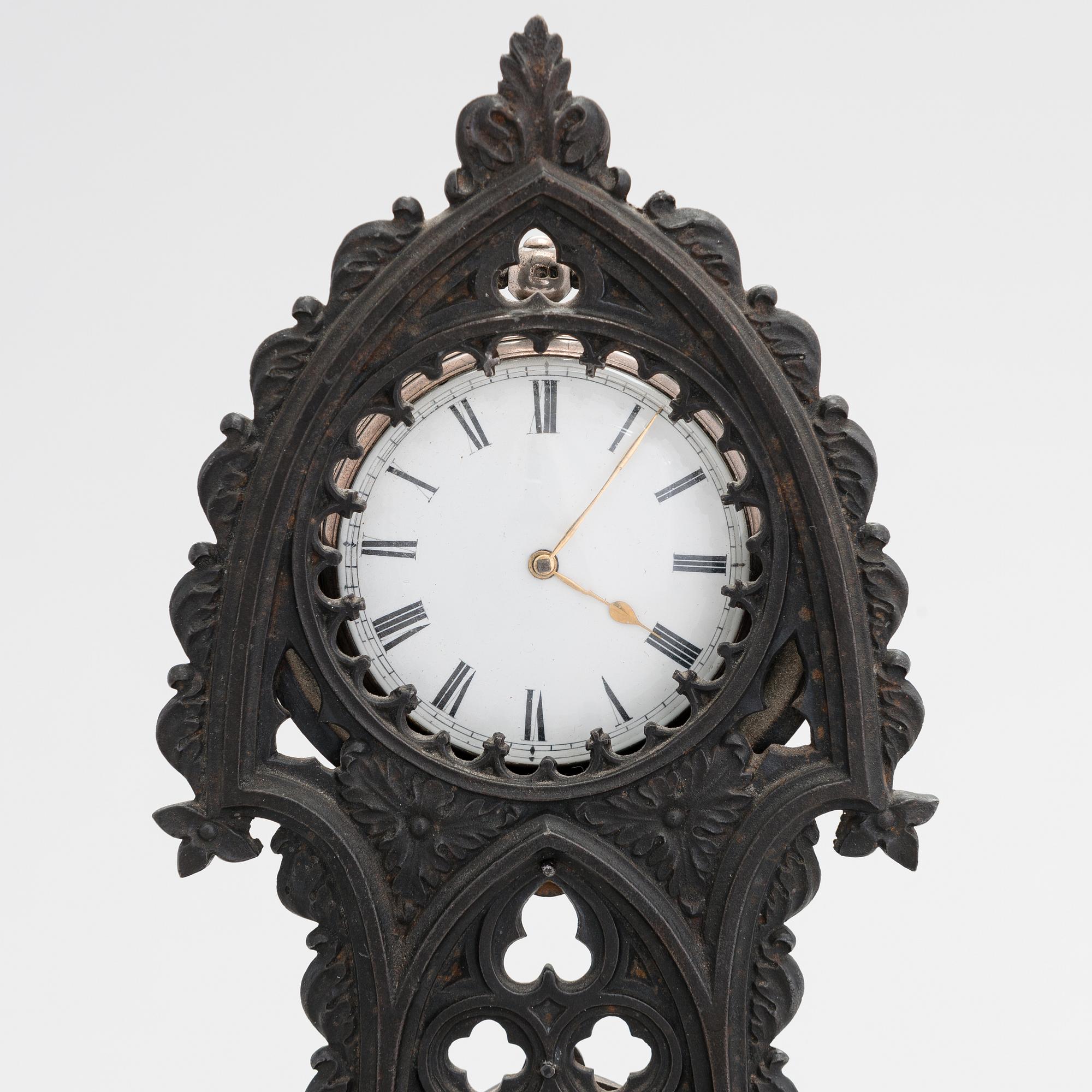 A neo-gothic cast iron pocket watch stand with a pocket watch. 19th century.