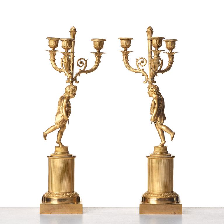 A pair of French Empire early 19th century three--light candelabra.
