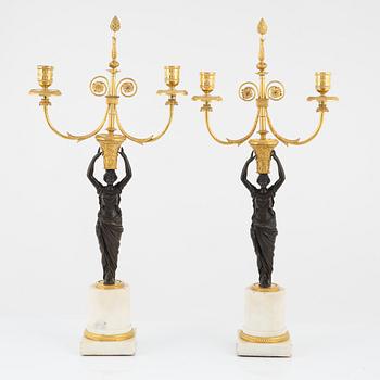 A pair of French Louis XVI ormolu, marble, and patinated bronze two-branch candelabra, late 18th century.