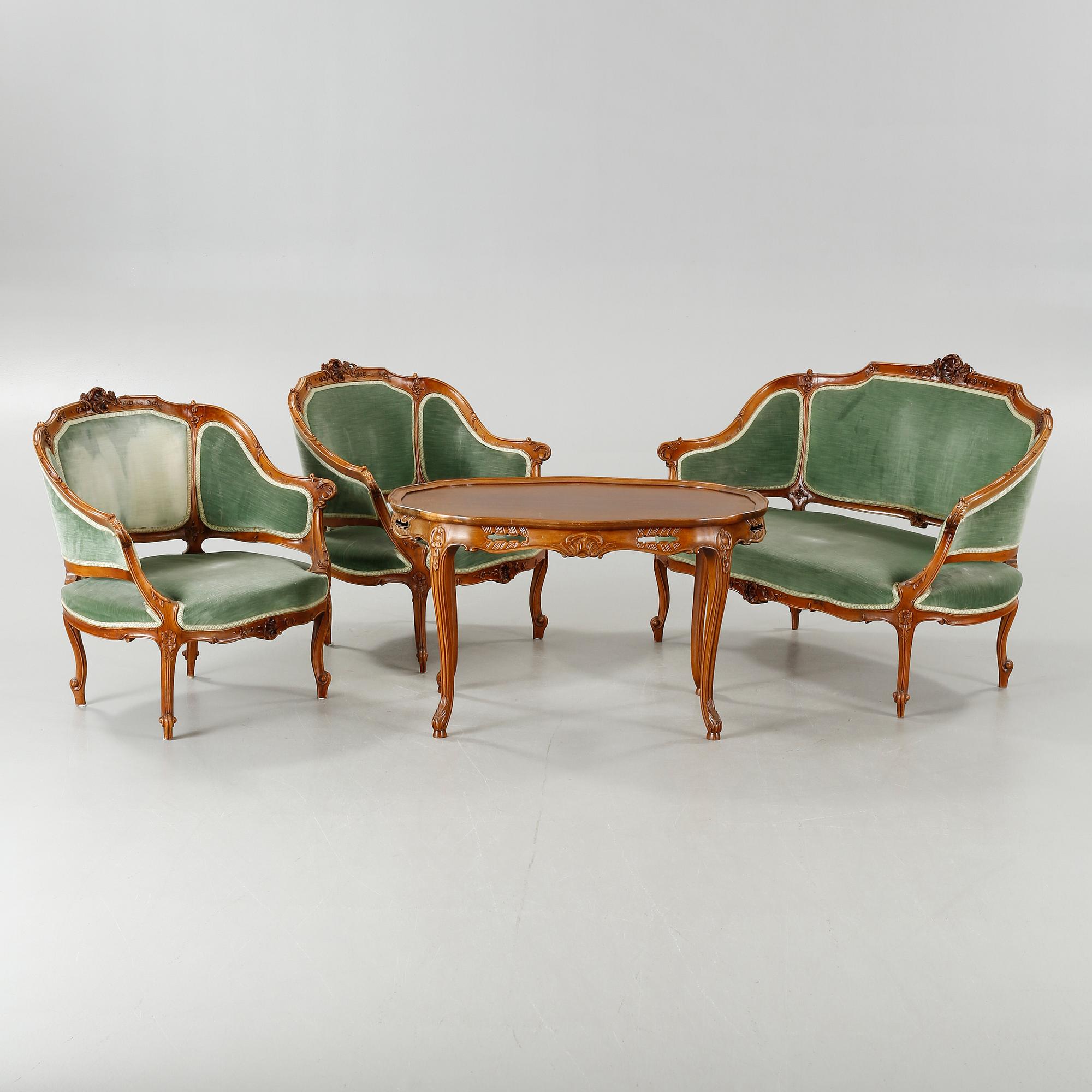 A rococo style sofa, two lounge chairs and a table, around the year 1900 and first half of the 20th century.