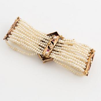 Bracelet, gold, eight-row with seed pearls and rubies.