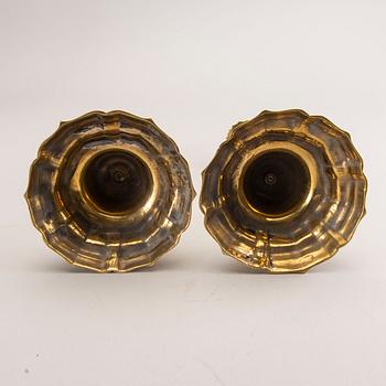 A pair of rococo brass candlesticks, possibly France.