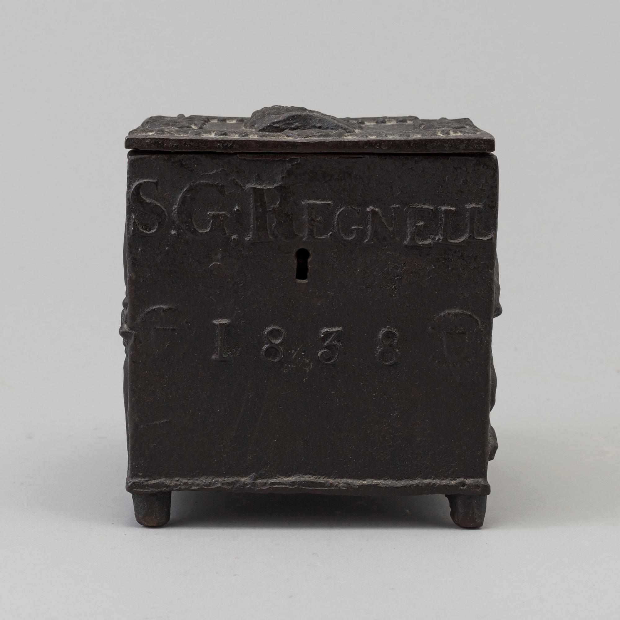 An empire cast iron tobacco box, dated 1838.