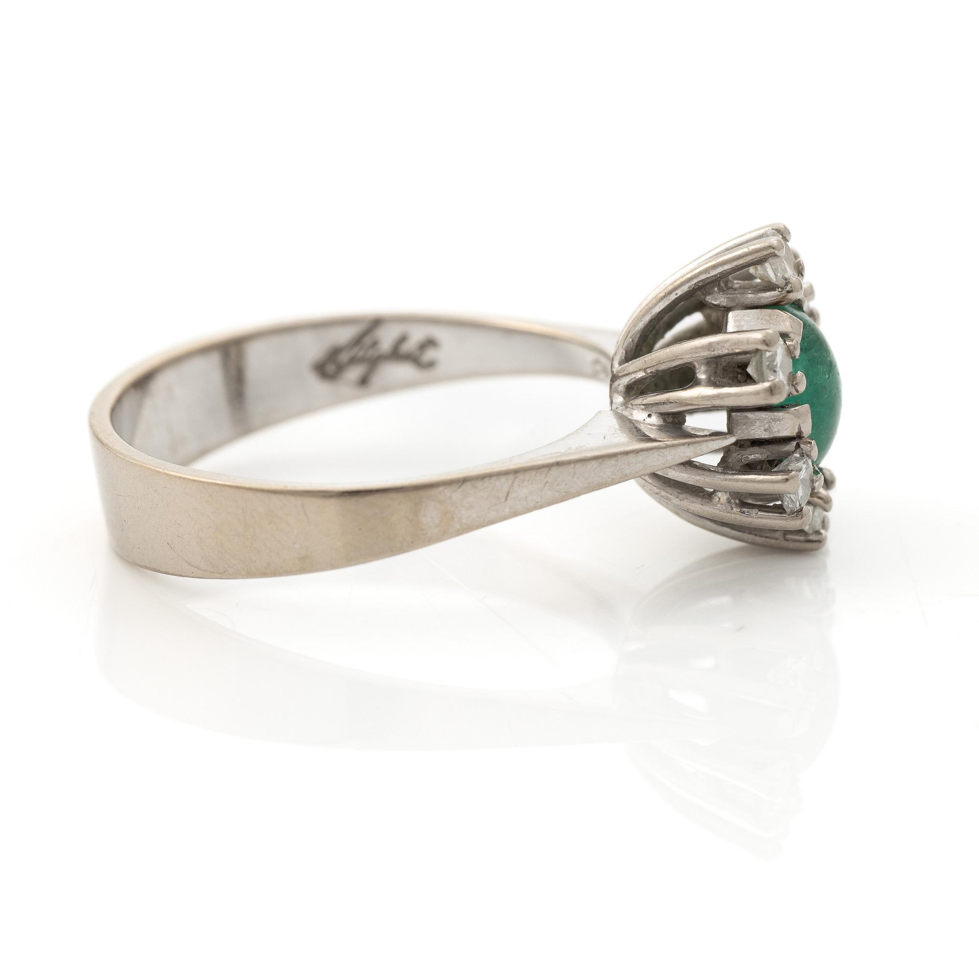 Ring 18K vitguld med en cabochonslipad smaragd och runda briljantslipade diamanter, Stockholm 1976.