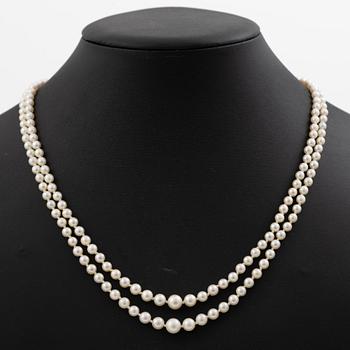 Double-row necklace with graduated cultured pearls, silver clasp set with paste stones.