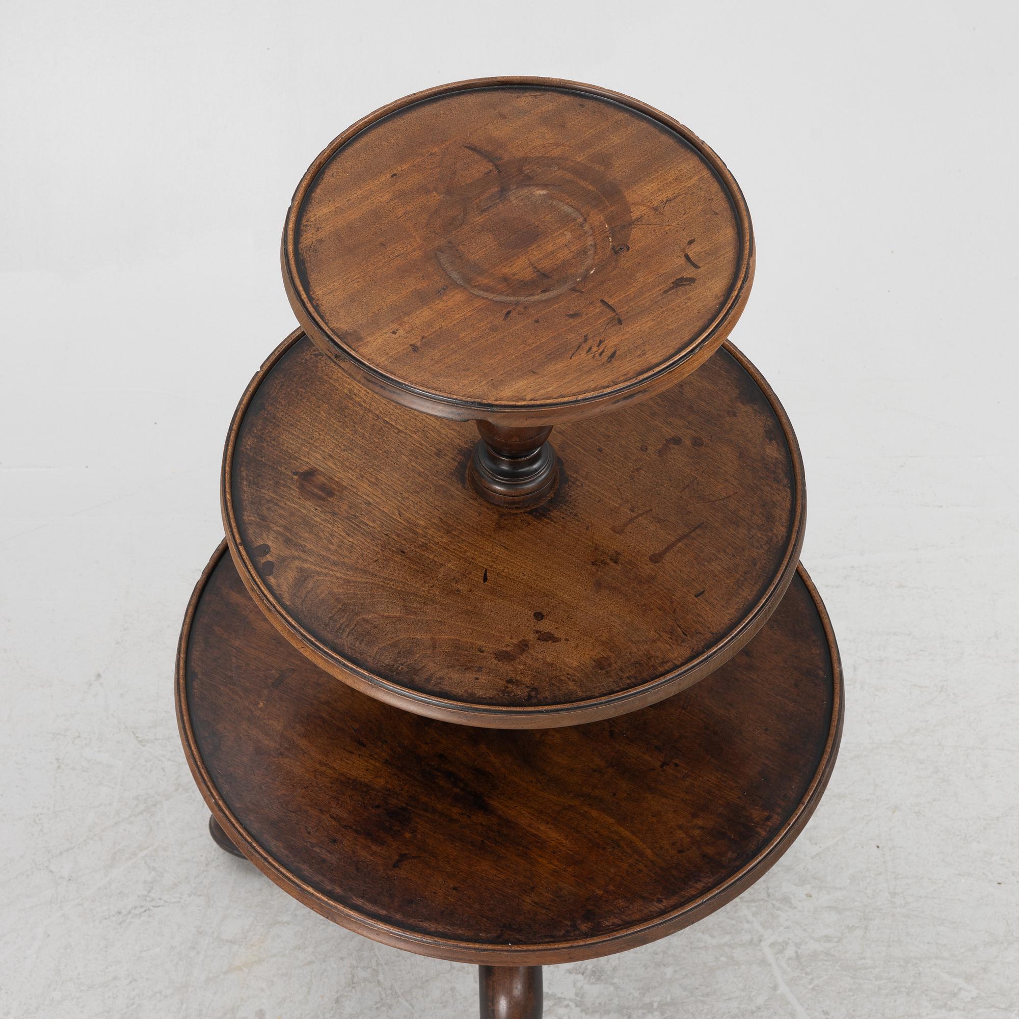 A mahogany three-tier table, England, circa 1900.
