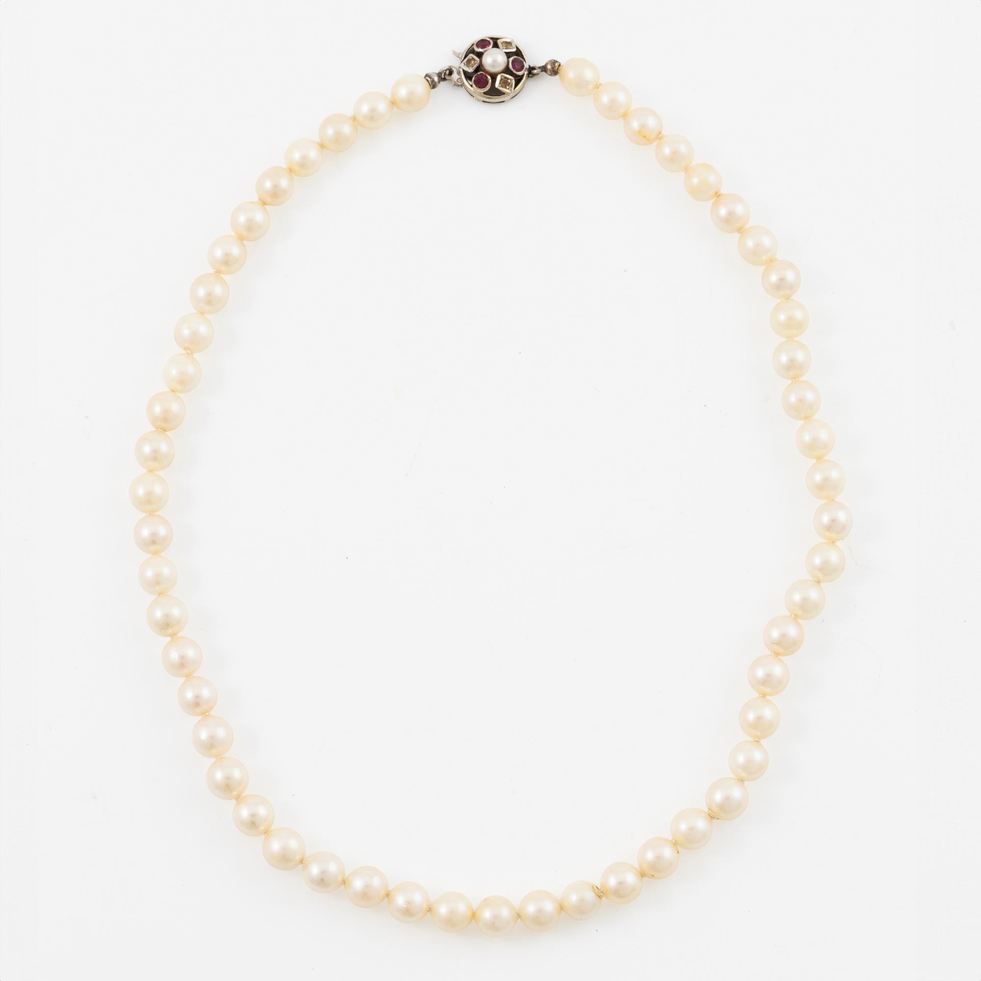 Necklace of cultured pearls with clasp in 18K gold set with white and red stones.