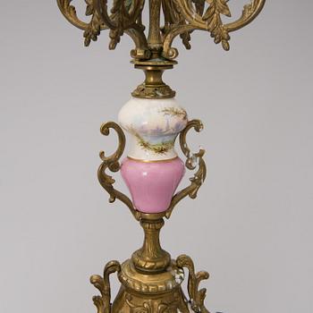 A pair of gilt-bronze Rococo Revival candelabra with porcelain decors, from the latter half of the 19th century.