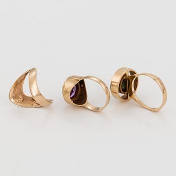 Three 14K gold rings, one with a synthetic, colour-change, sapphire and one with a green stone.