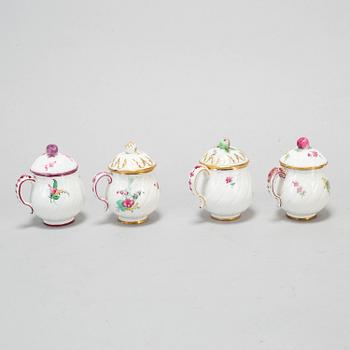 A set of four odd soft paste custard cups with covers, 18th Century.