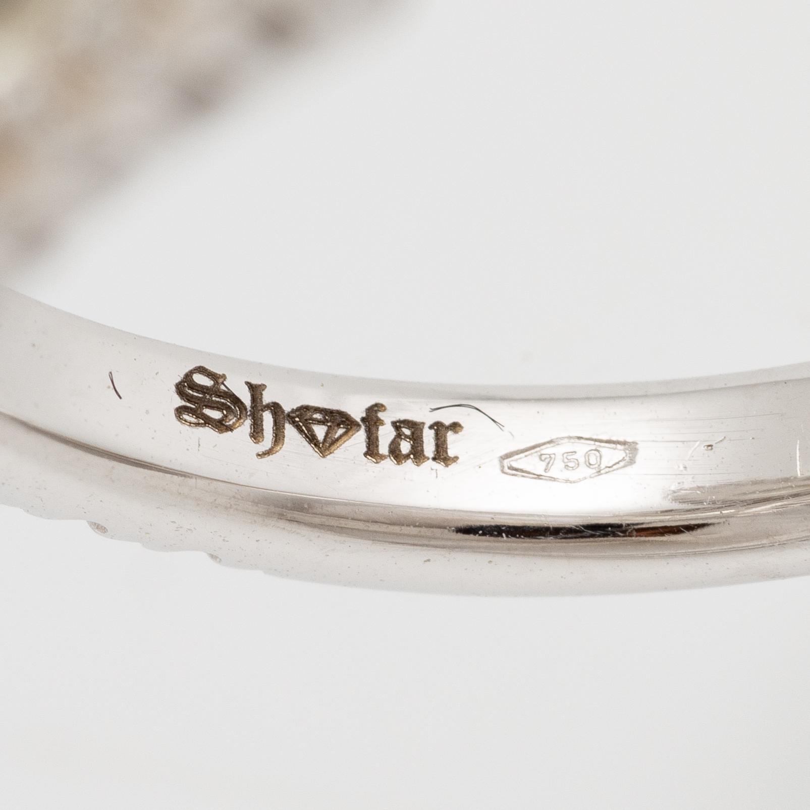 Crossover ring, 18K white gold set with pear-shaped and emerald-cut diamonds. Accompanied by GIA report.