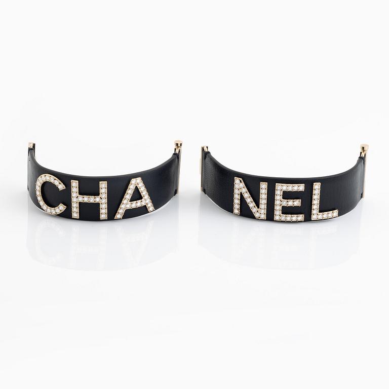 Chanel, a pair of black leather and rhinestone bracelets.