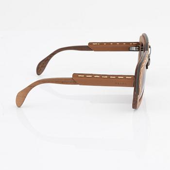 Prada, a pair of wood and leather sunglasses.