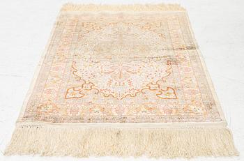 A silk Hereke rug, c. 85 x 55 cm.