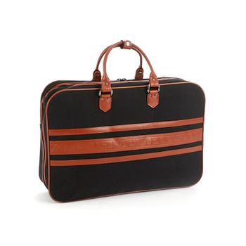 369. YVES SAINT LAURENT, a black canvas and brown leather suitcase.