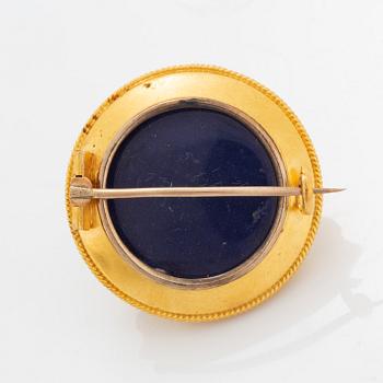 A cabochon-cut turquoise, 14K gold brooch.