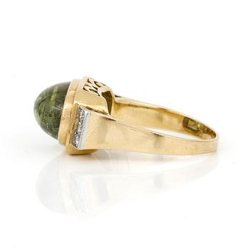 RING, 18K guld med åttkantslipade diamanter ca 0,12 ct och cabochonslipad grön turmalin, ca 8,04 ct. Vikt ca 8,01 g.