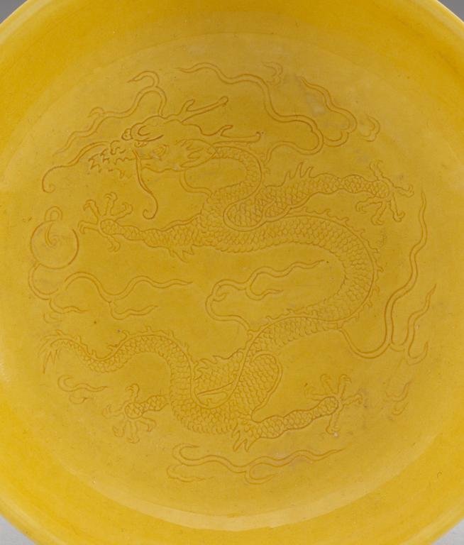 A pair of yellow-glazed incised dragon dishes, Qing dynasty with Qianlongs seal mark (1644-1912).