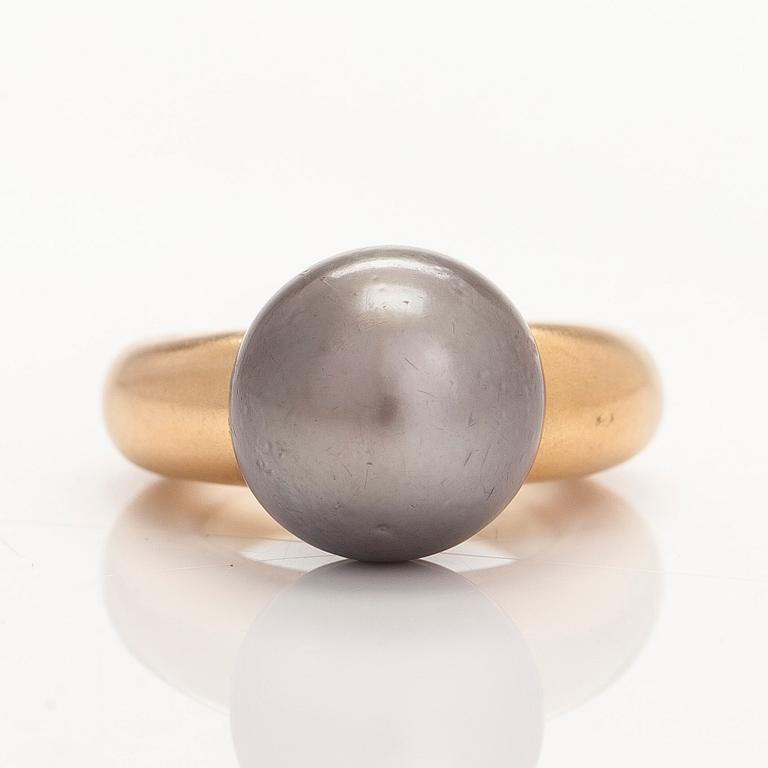 An 18K gold ring, with a cultured Tahiti pearl.