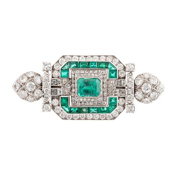 486. An 18K white gold Marchak art deco brooch set with step-cut emeralds.