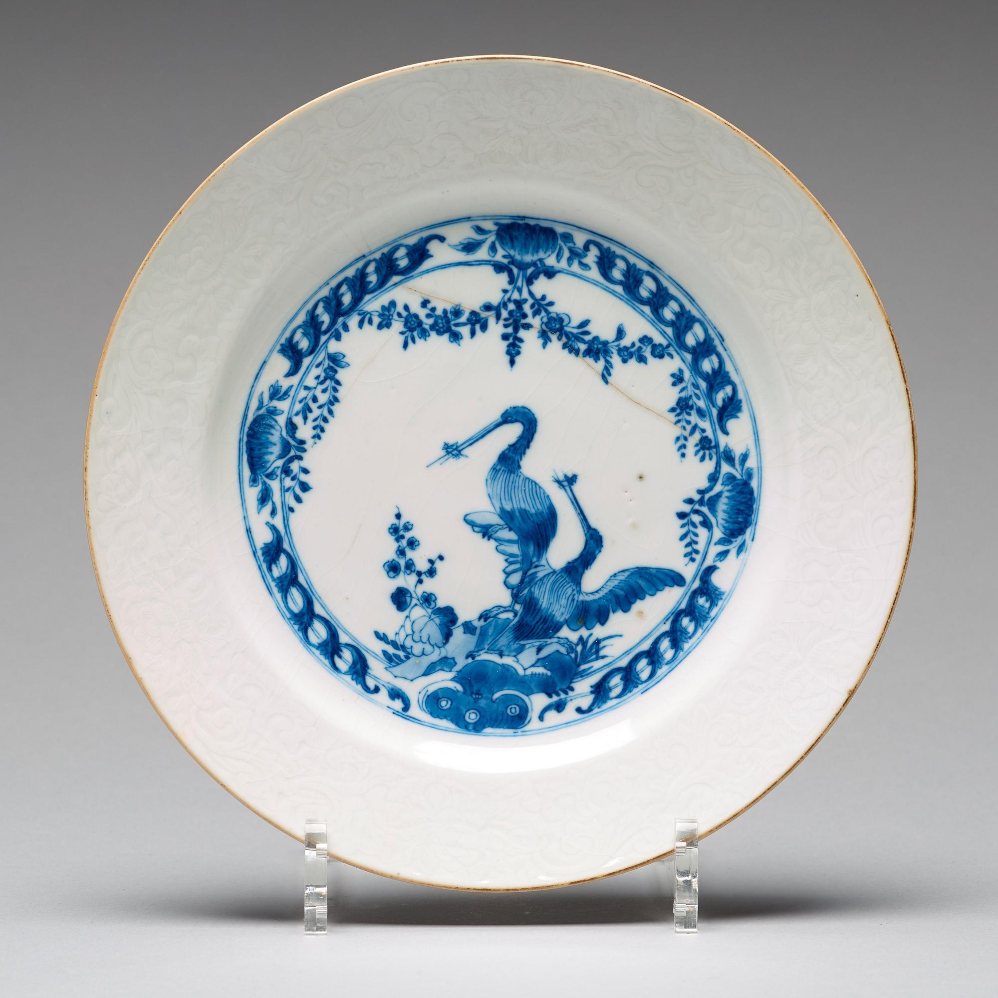 A set of four blue and white armorial dinner plates, Qing dynasty, 18th Century.