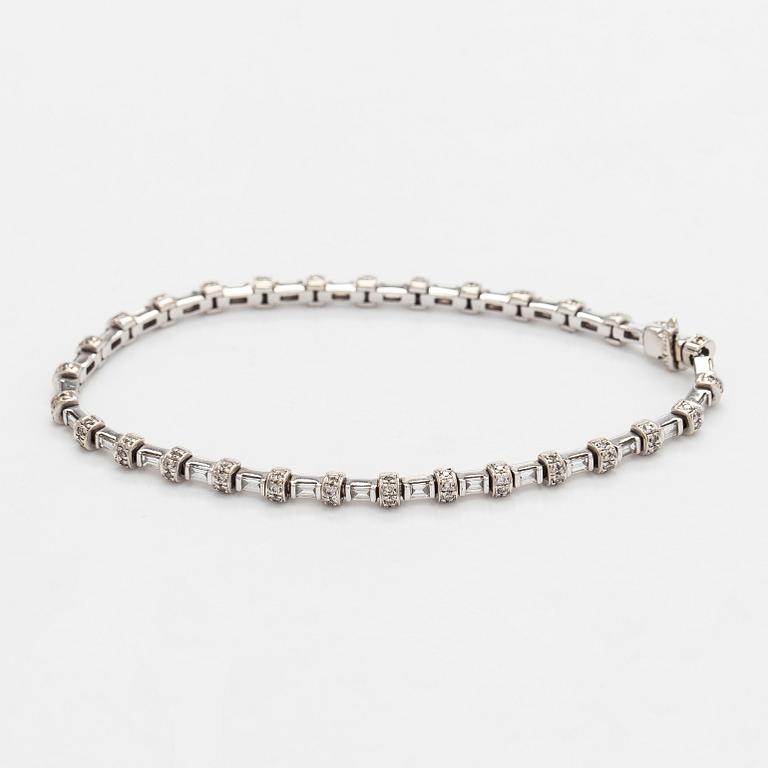An 18K white gold bracelet set with baguette and brilliant-cut diamonds.