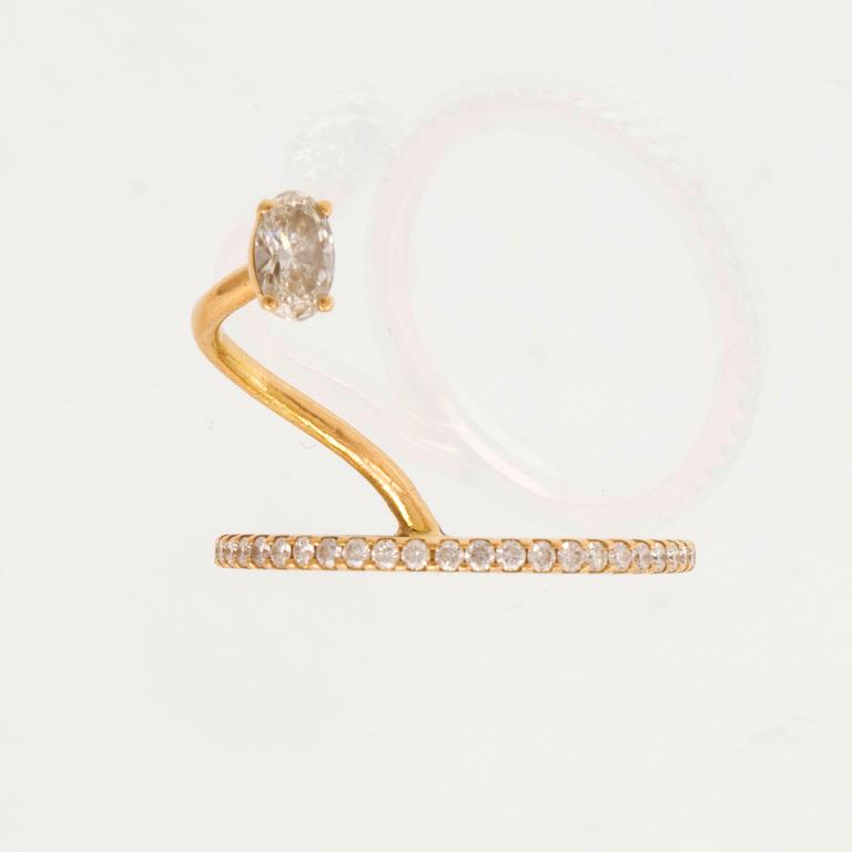 An 18K gold ring set with an oval cut and round brilliant cut diamonds by LWL Jewelry.