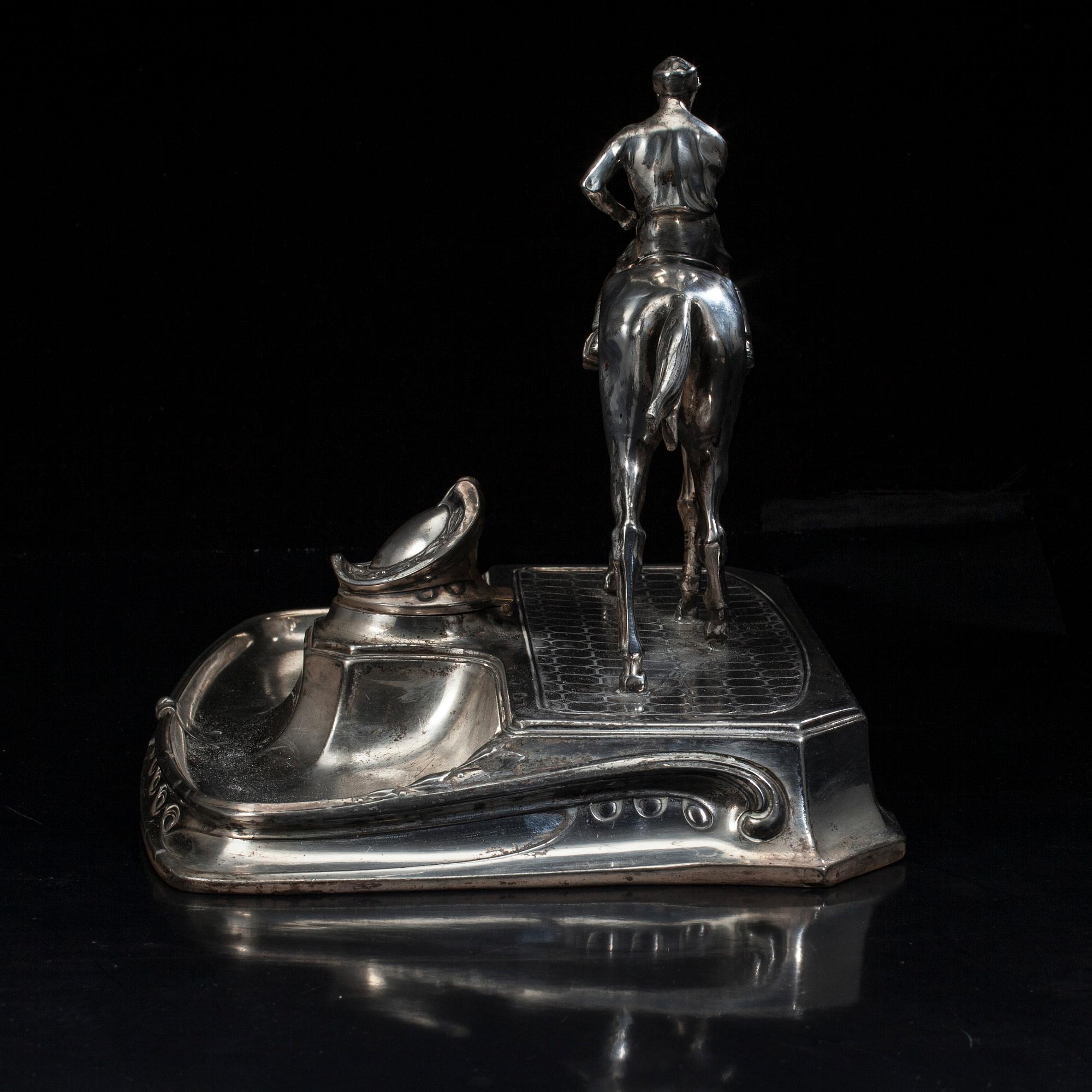 SKRIVSTÄLL med jockeyn Fred Archer till häst. Vitmetall. Sannolikt England, sent 1800-tal.